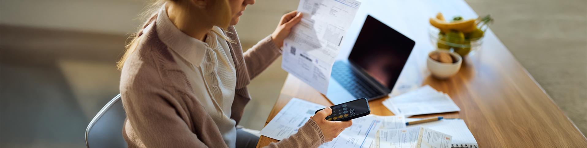 Femme se penchant sur ses finances. Ceci témoigne de potentiels problèmes financiers.